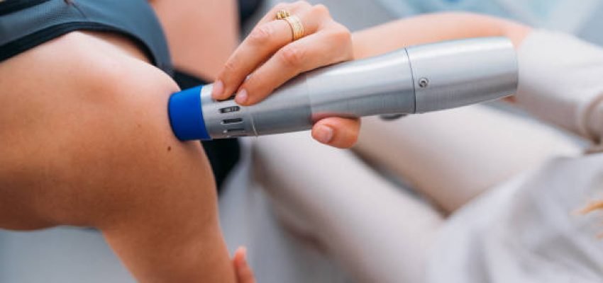 Close-up of a female hand holding instrument for shock wave therapy and treating patient's shoulder 
Shock wave therapy. The magnetic field, rehabilitation.